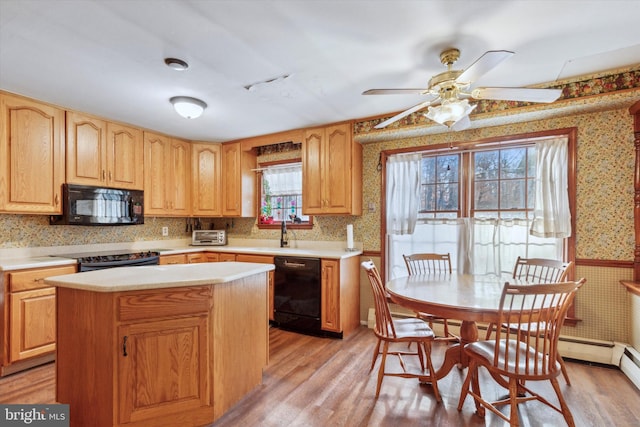 kitchen featuring ceiling fan, sink, light hardwood / wood-style flooring, a kitchen island, and black appliances