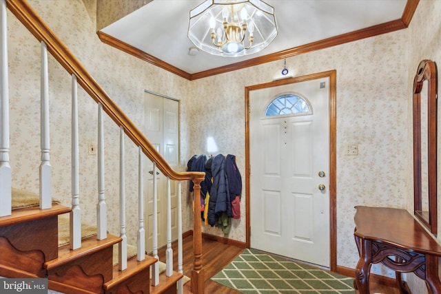 foyer entrance featuring a notable chandelier, wood-type flooring, and crown molding