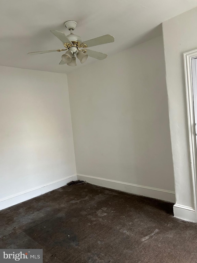 empty room featuring dark colored carpet and ceiling fan