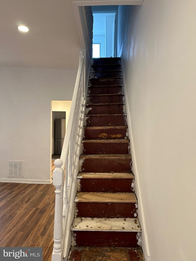 staircase featuring wood-type flooring