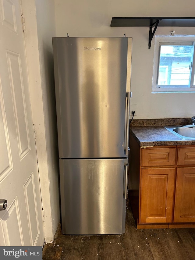 kitchen with dark hardwood / wood-style floors, sink, and stainless steel refrigerator