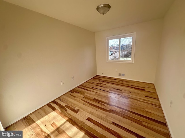 empty room with light hardwood / wood-style flooring