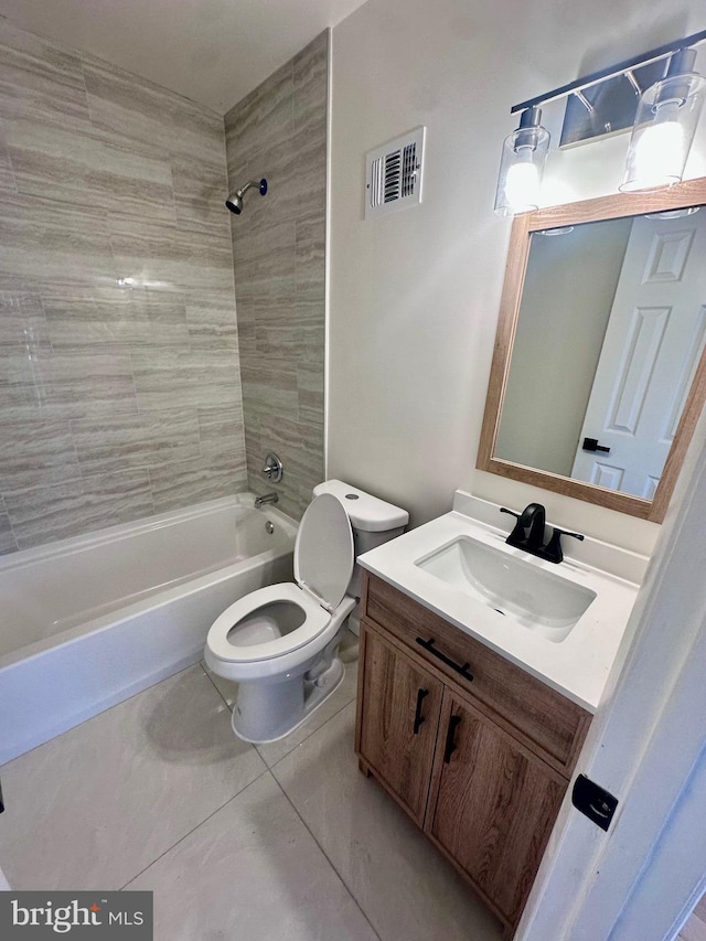 full bathroom featuring vanity, toilet, tiled shower / bath combo, and tile patterned flooring