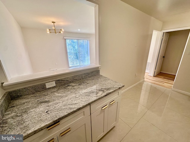 bathroom with a notable chandelier and tile patterned floors