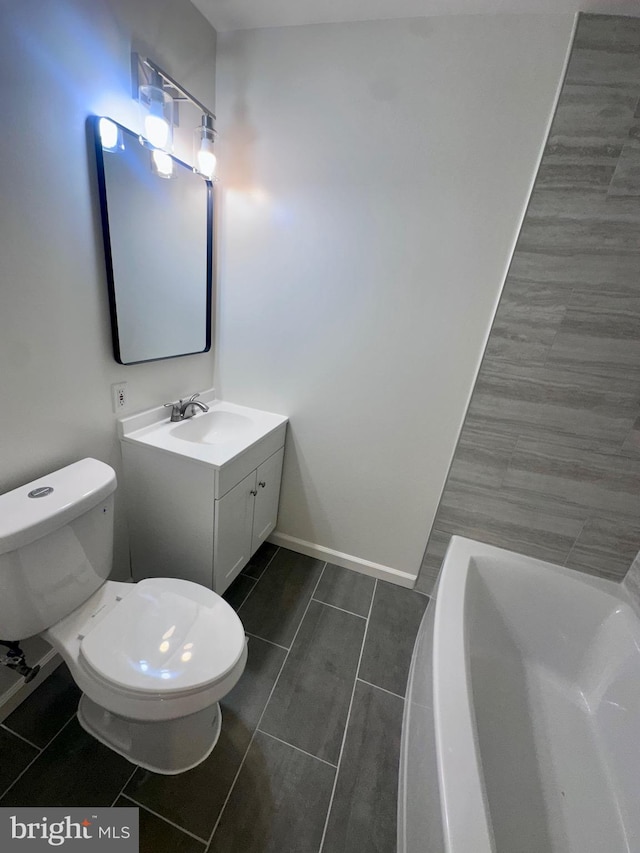 bathroom featuring vanity, a washtub, and toilet