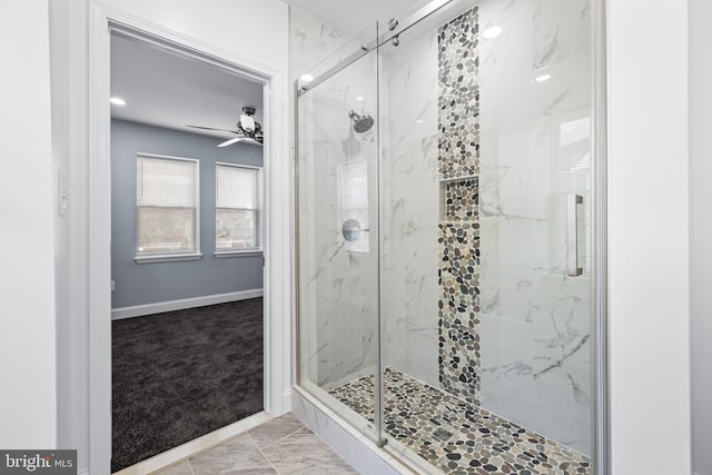 bathroom featuring a shower with door and ceiling fan