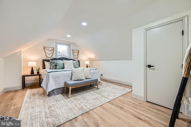 bedroom with light hardwood / wood-style floors and lofted ceiling