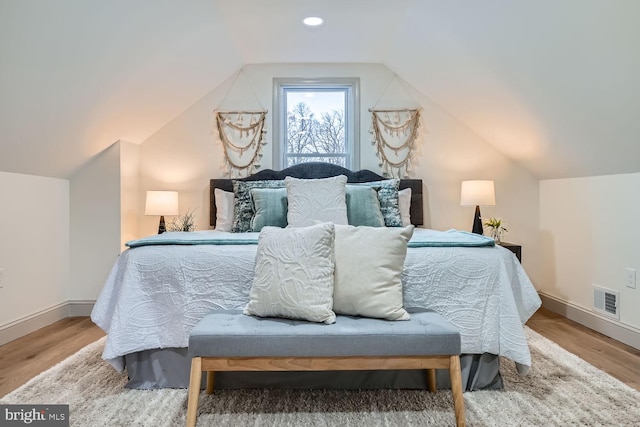 bedroom with lofted ceiling and wood-type flooring