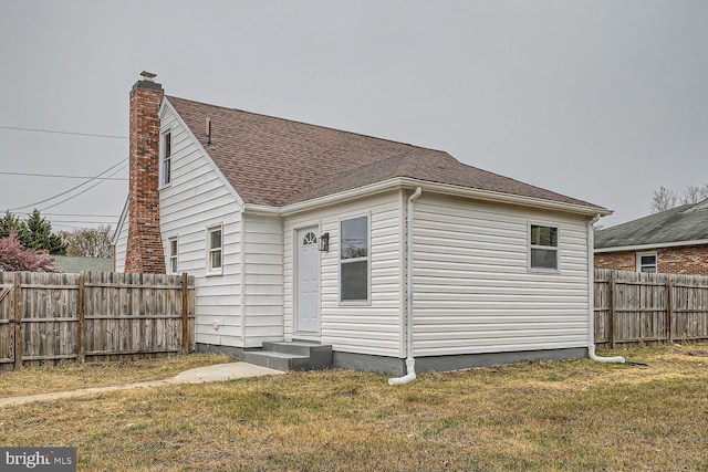 rear view of property with a lawn