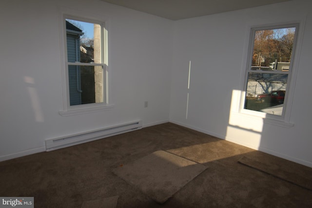 spare room with a baseboard radiator and dark carpet