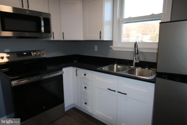 kitchen with sink, white cabinets, and appliances with stainless steel finishes