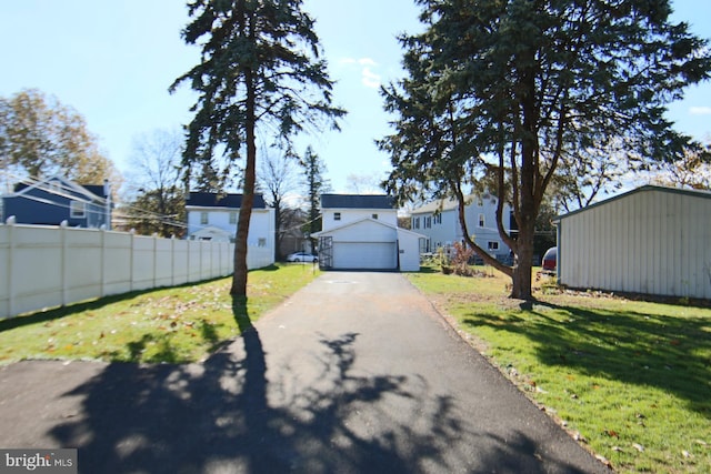 view of front of home with a front lawn, an outdoor structure, and a garage