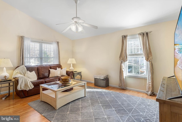 living room featuring hardwood / wood-style flooring, vaulted ceiling, ceiling fan, and a healthy amount of sunlight