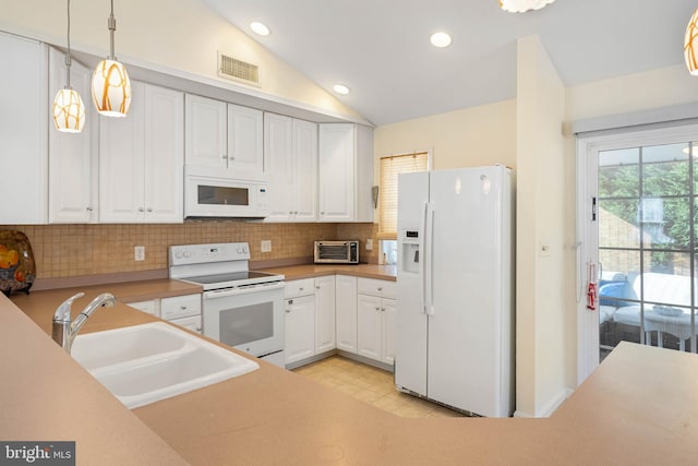 kitchen featuring white cabinetry, sink, vaulted ceiling, decorative light fixtures, and white appliances