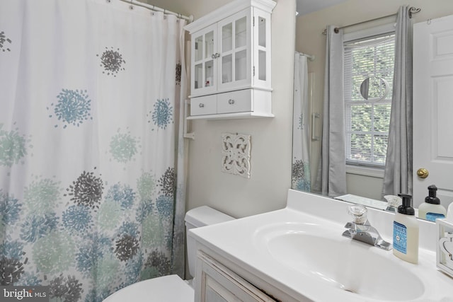 bathroom with vanity, toilet, and walk in shower