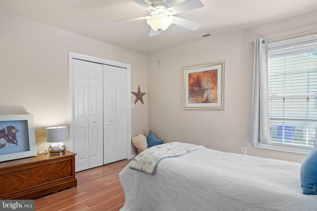 bedroom with ceiling fan, a closet, light wood-type flooring, and multiple windows