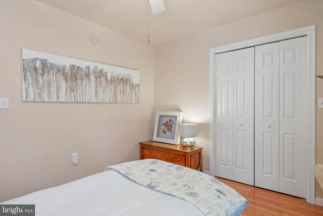 bedroom featuring ceiling fan, light wood-type flooring, and a closet