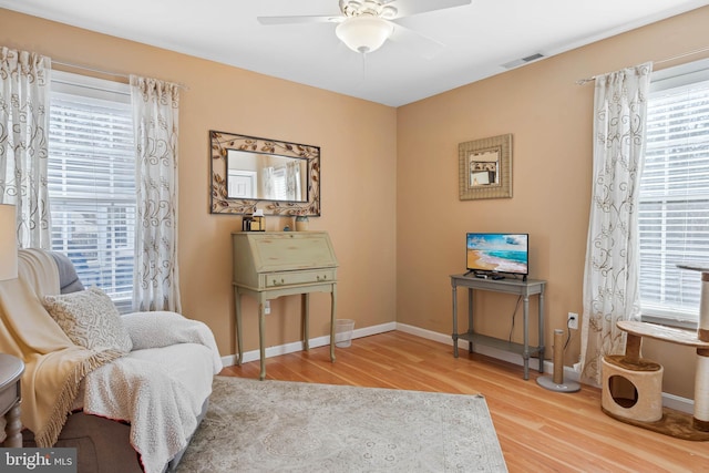 sitting room featuring a wealth of natural light, hardwood / wood-style floors, and ceiling fan