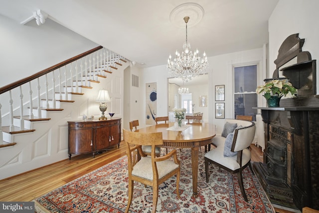 dining space with a chandelier and light wood-type flooring