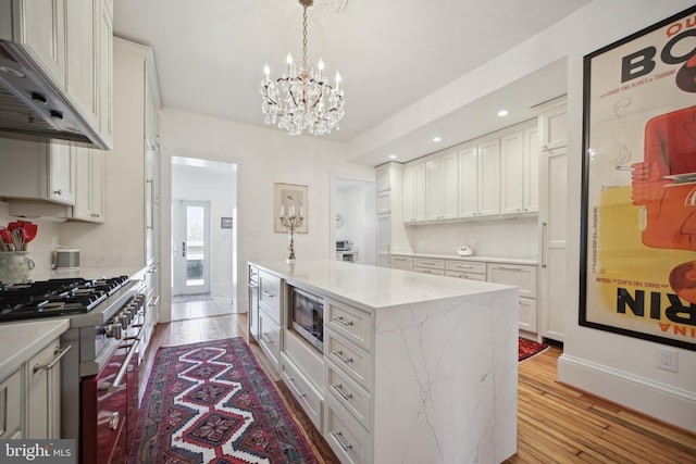 kitchen featuring white cabinets, stainless steel appliances, extractor fan, and a kitchen island