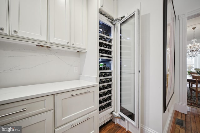 interior space featuring dark hardwood / wood-style floors, wine cooler, and a chandelier