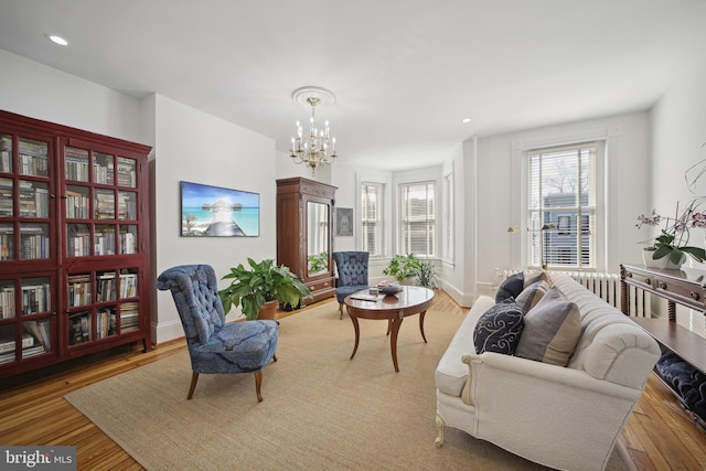 living area with light hardwood / wood-style flooring and a chandelier