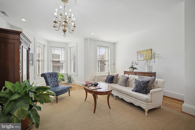 living room featuring light hardwood / wood-style flooring and an inviting chandelier