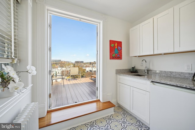 entryway featuring light tile patterned flooring, radiator, and sink