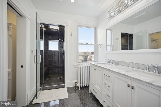 bathroom with radiator heating unit, vanity, and a shower with shower door