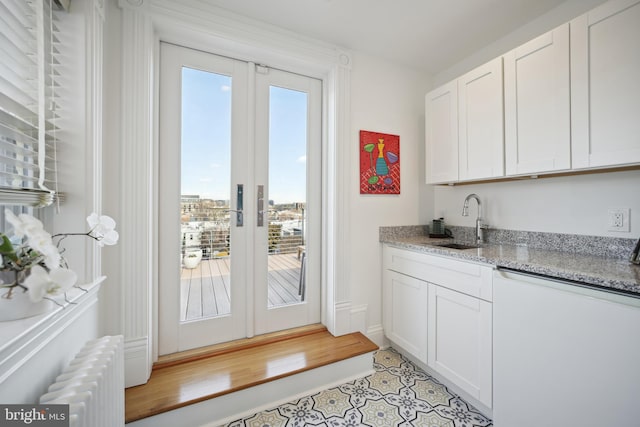 entryway with light tile patterned floors, sink, radiator, and french doors