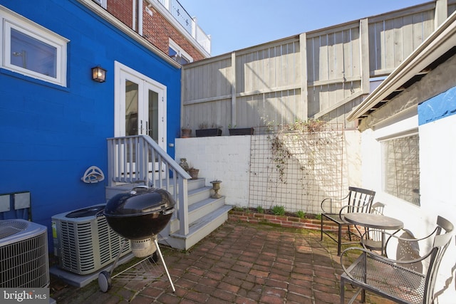 view of patio with central AC, a grill, and french doors