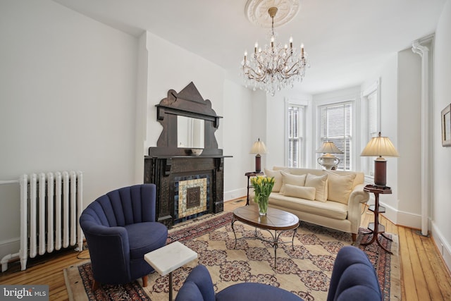 living room with wood-type flooring, radiator, and a notable chandelier