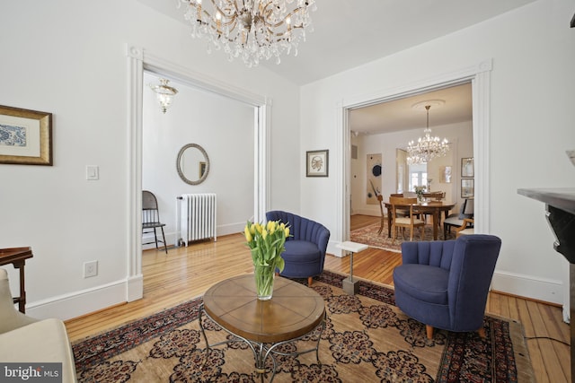 living room featuring hardwood / wood-style floors, radiator heating unit, and a chandelier