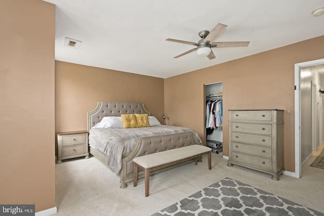 carpeted bedroom with ceiling fan, a walk in closet, and a closet