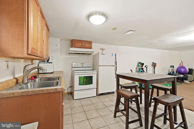 kitchen featuring white appliances, sink, and light tile patterned floors