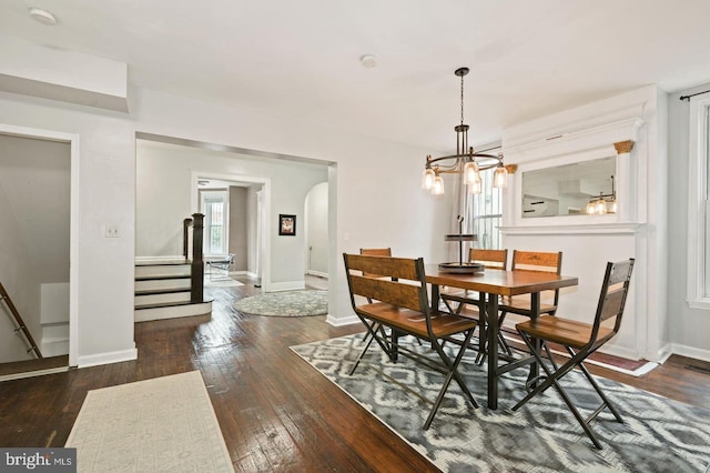 dining room featuring dark hardwood / wood-style floors, a healthy amount of sunlight, and a chandelier