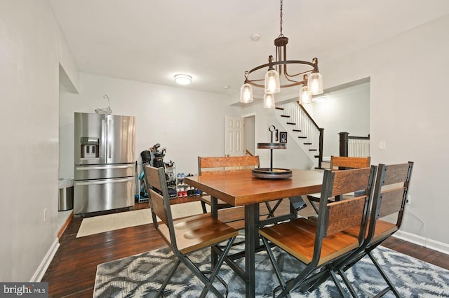 dining area with dark hardwood / wood-style floors and an inviting chandelier