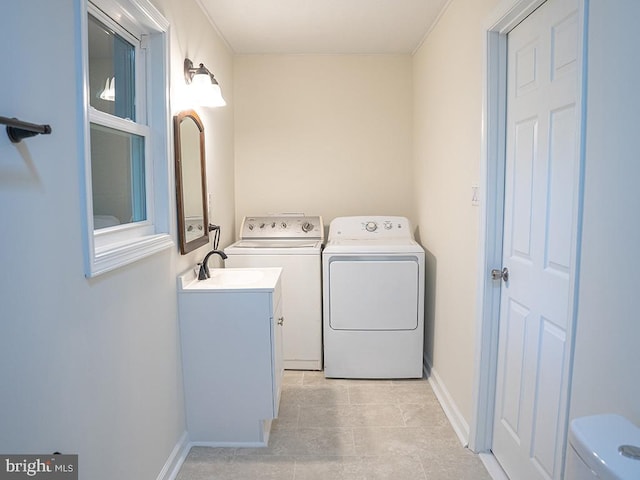 washroom with washer and dryer, light tile patterned flooring, and sink