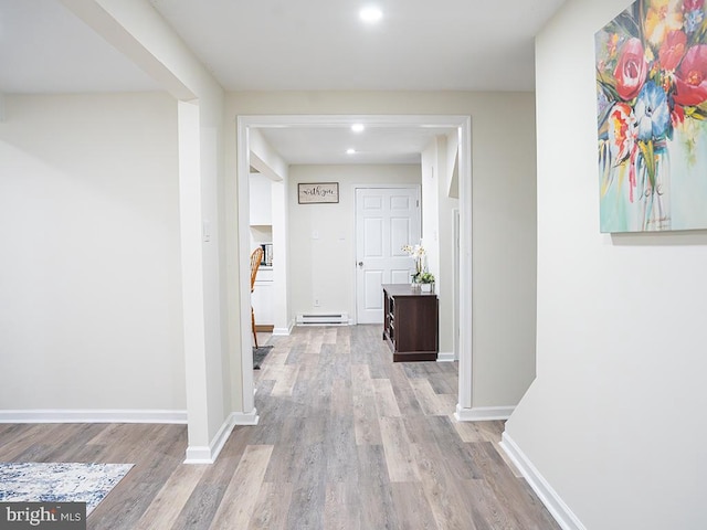 hallway featuring a baseboard heating unit and light wood-type flooring