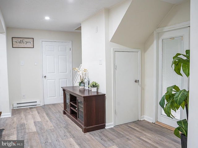 interior space featuring a baseboard heating unit and light wood-type flooring