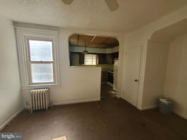 interior space featuring ceiling fan, a textured ceiling, and radiator