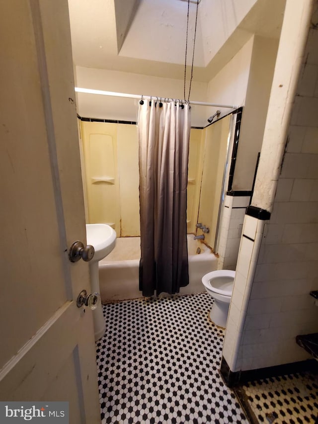 bathroom with shower / bath combo and toilet