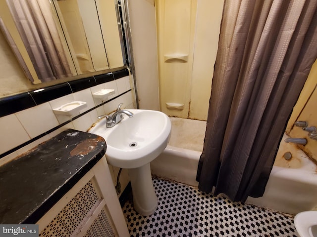 bathroom with shower / tub combo and tasteful backsplash