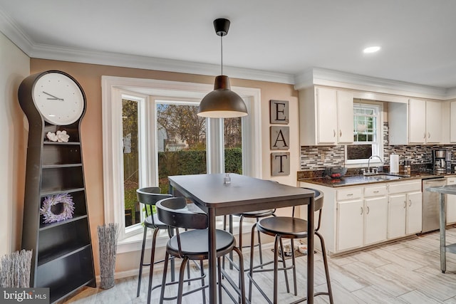 kitchen featuring a wealth of natural light, white cabinets, and stainless steel dishwasher