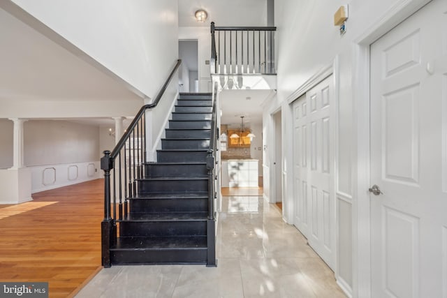 stairway with a high ceiling and an inviting chandelier