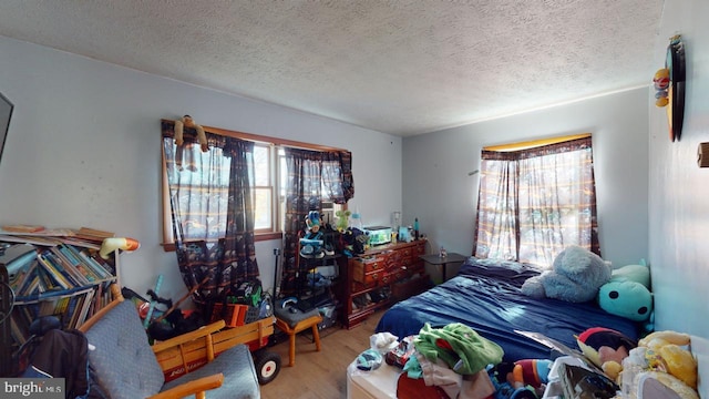 bedroom featuring wood-type flooring and a textured ceiling