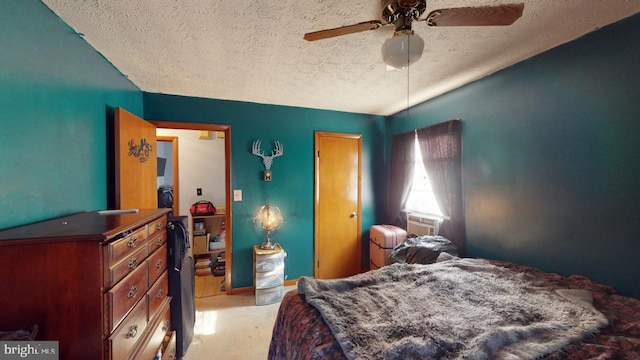 carpeted bedroom featuring ceiling fan and a textured ceiling