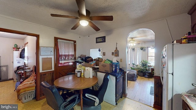 dining space featuring ceiling fan, a textured ceiling, and light hardwood / wood-style flooring