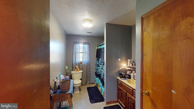 bathroom with tile patterned floors, walk in shower, vanity, a textured ceiling, and toilet