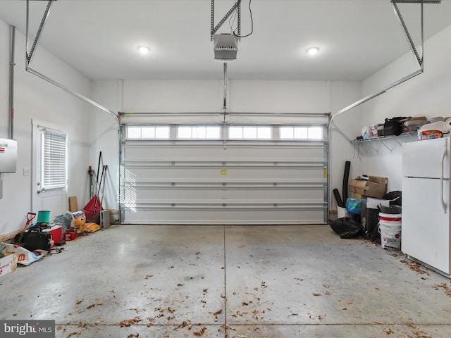 garage with white fridge and a garage door opener